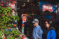 Asian couple walking past flower gift shop in Flushing Chinatown