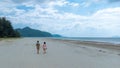 Asian couple walks on a beautiful beach stretching in nature