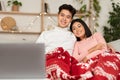 Asian Couple Watching Christmas Movies On Laptop Online At Home Royalty Free Stock Photo