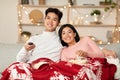 Asian Couple Watching Christmas Movies On TV Sitting At Home Royalty Free Stock Photo