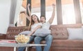 Asian couple watching TV sitting on a couch at home