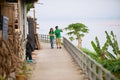 Asian couple wearing green t-shirts walks by the Mekong riverside in Chiang Khan, Thailand.