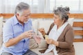 Asian couple woman caring sick old man by giving pill or drug at home