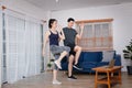 Asian couples exercise indoors together By following a trainer taught online in a laptop. Royalty Free Stock Photo