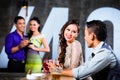 Asian couples flirting and drinking at nightclub bar Royalty Free Stock Photo