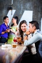 Asian couples flirting and drinking at nightclub bar Royalty Free Stock Photo