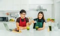 Asian couples are preparing healthy breakfast by young female pouring milk into the glass green tea Royalty Free Stock Photo