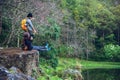 Couple sitting on rocks and taking pictures nature, flowers. at Paphiopedilum orchid conservation center Royalty Free Stock Photo