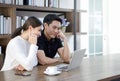 Asian couples spend time together in the living room. Both had a serious expression on their faces after seeing a quote for a home