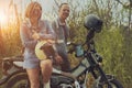 asian couples standing beside enduro motorcycle with high green grass background Royalty Free Stock Photo