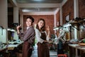 An asian craftsman and craftswoman smiling with a thumbs up