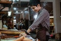 Asian craftsman loves to work with leather making basic shapes