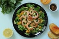 Asian cuisine king prawn salad with toasted baguette and lemon on a black plate Royalty Free Stock Photo