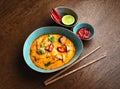 Asian cuisine. Red soup with mushrooms in a blue plate.