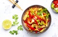 Asian cuisine stir fried chicken breast, red paprika and zucchini with sesame seeds, lime and soy sauce in ceramic bowl. White Royalty Free Stock Photo