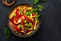 Asian cuisine, stir fry with chicken, red paprika pepper and zucchini bowl. Black kitchen table background, top view, copy space Royalty Free Stock Photo