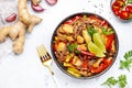 Asian cuisine, stir fry noodles with chicken and vegetables, red paprika and zucchini, sesame seed and soy sauce in bowl. White Royalty Free Stock Photo