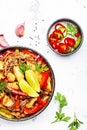 Asian cuisine, stir fry noodles with chicken and vegetables, red paprika and zucchini, sesame seed and soy sauce in bowl. White Royalty Free Stock Photo