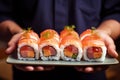 Asian culinary expertise: chef holds a plate of sushi