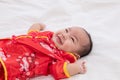 Asian cute baby boy Chinese Cheongsam costume toddler lie down on bed at home smiling laughing good humored infant Chinese