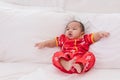 Asian cute baby boy Chinese Cheongsam costume toddler lie down on bed at home smiling laughing good humored infant Chinese