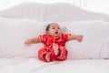Asian cute baby boy Chinese Cheongsam costume toddler lie down on bed at home smiling laughing good humored  infant Chinese Royalty Free Stock Photo