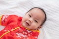 Asian cute baby boy Chinese Cheongsam costume toddler lie down on bed at home smiling laughing good humored infant Chinese