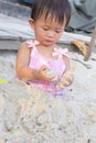 Asian cute baby girl playing toys on sand beach. Royalty Free Stock Photo