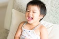 Asian cute baby girl smiling and holding a glass of water. Concept of a healthy lifestyle.. Royalty Free Stock Photo