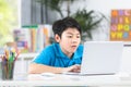 Asian cute boy using laptop computer. Royalty Free Stock Photo