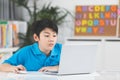 Asian cute boy using laptop computer. Royalty Free Stock Photo