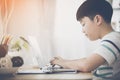 Asian cute boy using laptop computer. Royalty Free Stock Photo