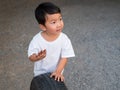 Asian cute child boy playing auto car tire wheel with smiling and surprised face, looking  interesting things Royalty Free Stock Photo