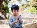 Asian cute child boy playing clay outdoor with funny face in garden.