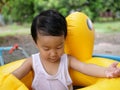 Asian cute child boy playing outdoor in yellow duck rubber band with rural nature background. Royalty Free Stock Photo