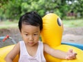 Asian cute child boy playing outdoor in yellow duck rubber band with rural nature background. Royalty Free Stock Photo