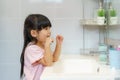 Asian cute child girl or kid brushing her teeth by toothbrush in the bathroom. Dental hygiene Healthcare concept Royalty Free Stock Photo