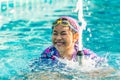 Asian cute child girl in the swimming pool, playing a small fountain in the pool, positive emotion, big smiling, natural sunlight Royalty Free Stock Photo