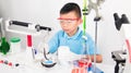 Asian cute child learning science in laboratory on gray whit background.
