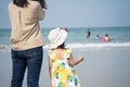 Asian cute girl and her mother walking or running or playing on the beach on summer holidays. Children with beautiful sea, sand Royalty Free Stock Photo