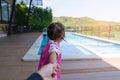 Asian cute girl kid pull hand father walk to the pool.
