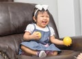 Asian cute girl playing ball toy on chair Royalty Free Stock Photo
