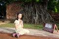 Asian cute girl with respecting or pray, Buddha head entwined wi Royalty Free Stock Photo