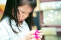 Asian cute girl are serious about removing duct tape. Concept of learning how to solve problems. Kid aged 4 years old Royalty Free Stock Photo