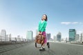 Asian cute girl with a suitcase and happy expression standing on the asphalt road Royalty Free Stock Photo