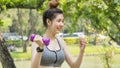 Asian cute healthy fit and firm slim girl happy to standing workout with small dumbbell in position bicep curls lifting  at Royalty Free Stock Photo