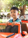 Asian cute kid boy sitting on orange car toy. Royalty Free Stock Photo