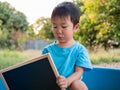 Asian cute little child boy holding empty blank black board with happy smiling surprised face,wow mouth Royalty Free Stock Photo