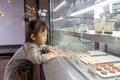 Asian cute little girl looking excited in bakery counter