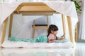 Asian cute little girl watching cartoon in smartphone while lying in a blanket fort in living room at home for perfect hideout Royalty Free Stock Photo